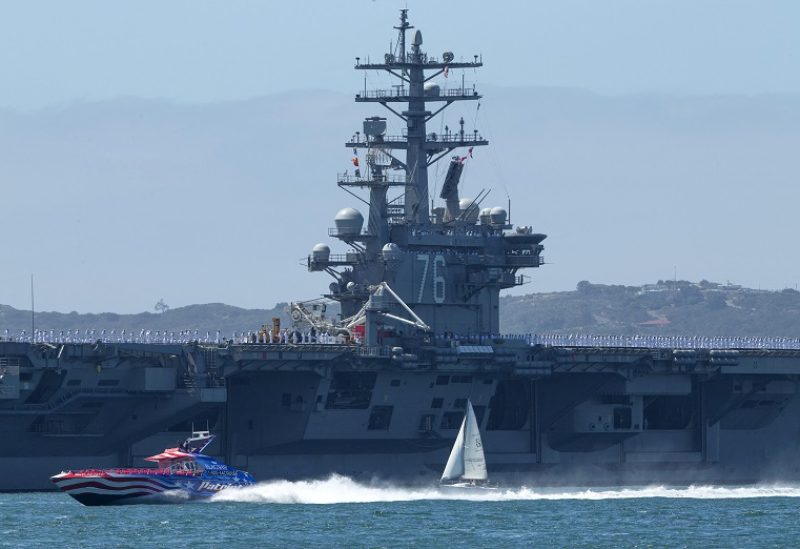 FILE PHOTO: A speed boat and a sail boat pass as the USS Ronald Reagan, a Nimitz-class nuclear-powered super carrier, departs for Yokosuka, Japan from Naval Station North Island in San Diego, California August 31, 2015. The Reagan is replacing the USS George Washington as part of a complicated three-carrier swap that exchanges crews for ships, saving the Navy millions in moving costs. REUTERS/Mike Blake/File Photo