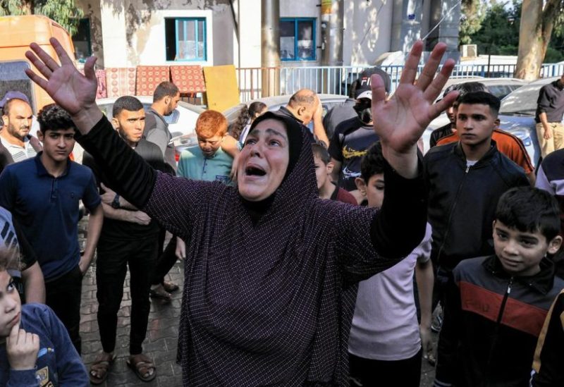 A woman reacts as people gather at the site of al-Ahli Arab Hospital in central Gaza on October 18, 2023 in the aftermath of an overnight blast there. (AFP)