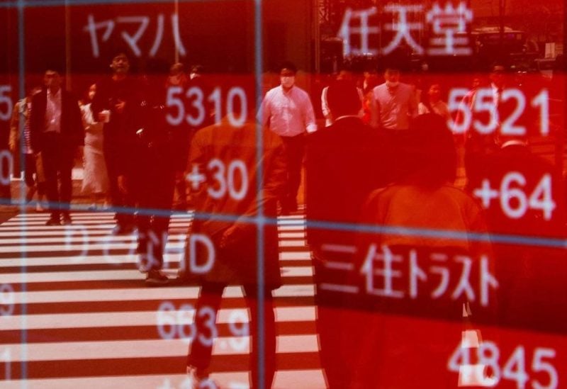 Reflection of the image of passers-by on a screen displaying stock movements on the Japanese Stock Exchange in central Tokyo