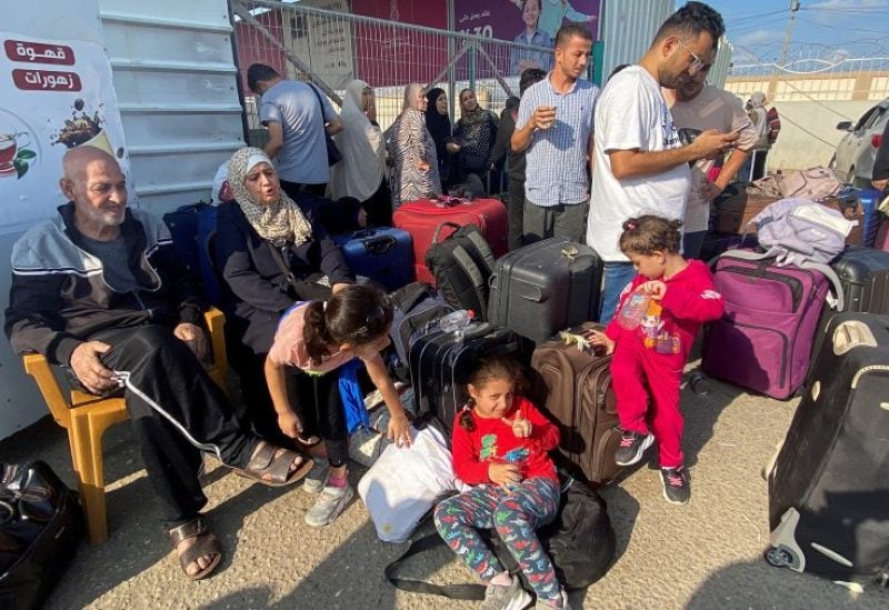 Palestinians with dual citizenship wait outside the Rafah border crossing with Egypt, in the hope of getting permission to leave Gaza, amid the ongoing conflict between Israel and Palestinian Islamist group Hamas, in Rafah in the southern Gaza Strip, November 1, 2023. REUTERS/Arafat Barbakh