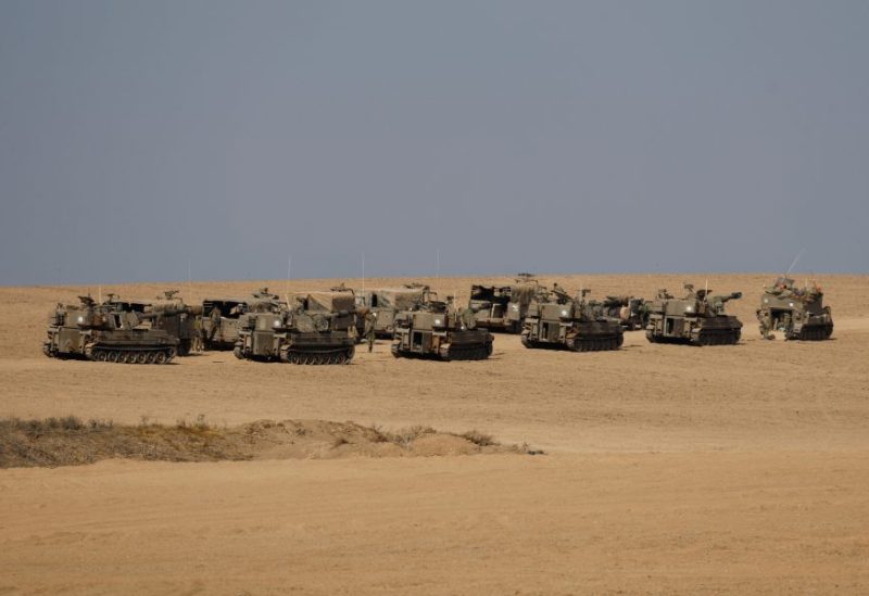 Israel soldiers stand next to artillery units near the Israeli side of the border between Israel and the Gaza Strip, November 3, 2023. REUTERS/Amir Cohen