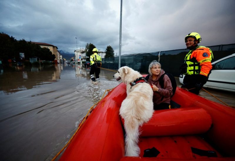 Carla and her dog Dante are carried on a fire brigade dinghy after being rescued in the aftermath of Storm Ciaran, in Oste, in Tuscany region, Italy, November 3, 2023. REUTERS/Yara Nardi