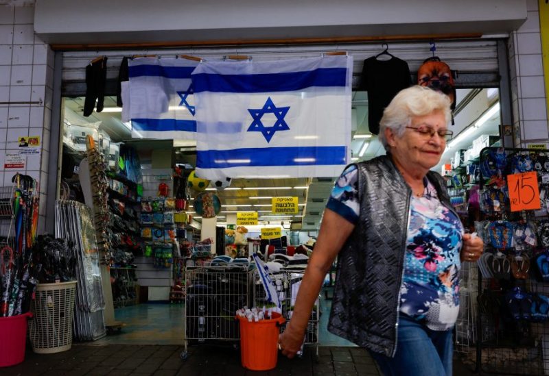 A local woman passes by a shop that displays an Israeli flag in the city of Tiberias, Israel, November 8, 2023. REUTERS/Alexander Ermochenko/File photo
