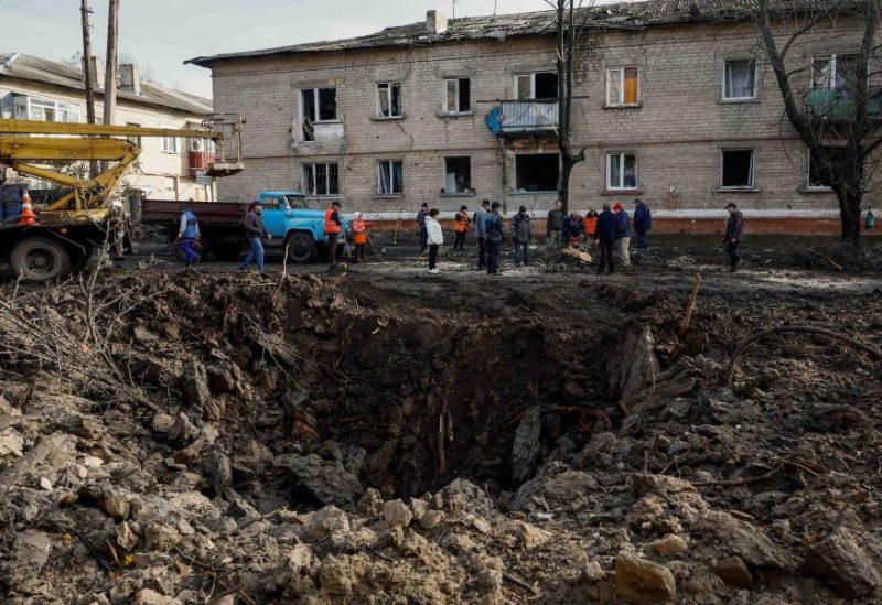 Local services workers remove debris near the crater, after a Russian missile strike at the site of damaged residential houses, amid Russia's attack on Ukraine, in the town of Selydove, Donetsk region, Ukraine November 15, 2023. REUTERS/Alina Smutko