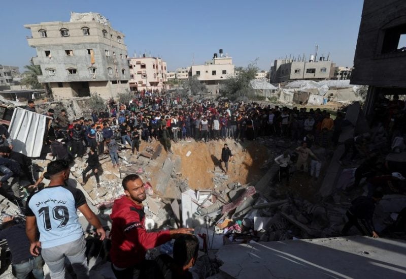 Palestinians gather as others search for casualties at the site of an Israeli strike on a house in Rafah, amid the ongoing conflict between Israel and the Palestinian Islamist group Hamas, in the southern Gaza Strip November 23. REUTERS/Ibraheem Abu Mustafa