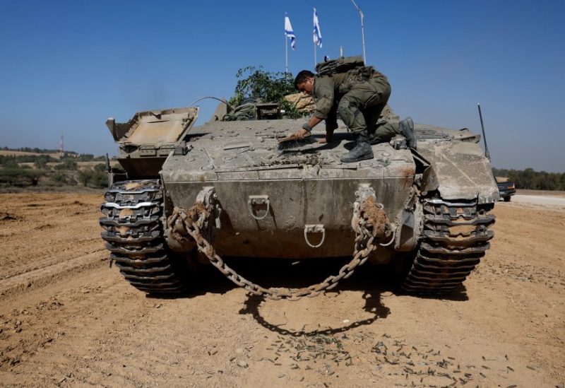 An Israeli soldier clears an armoured personnel carrier (APC), near Israel's border after leaving Gaza, during the temporary truce between the Palestinian Islamist group Hamas and Israel, in Israel, November 24, 2023. REUTERS/Amir Cohen