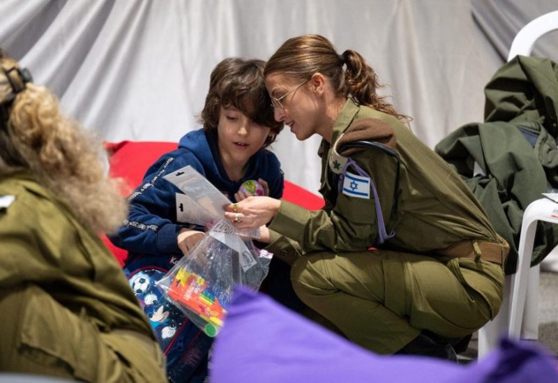 Nave Shoham, 8, a released Israeli hostage, interacts with an Israeli soldier shortly after his arrival in Israel on November 25, after being held hostage by the Palestinian militant group Hamas in the Gaza Strip, at an unknown location in Israel, in this handout picture released by the Israeli Prime Minister's Office on November 26, 2023. Israeli Prime Minister's Office/Handout via REUTERS