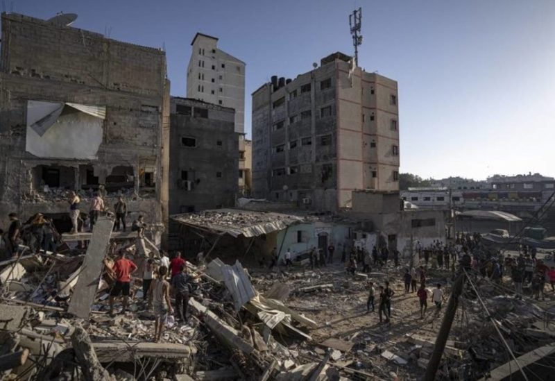 Palestinians look at the destruction after Israeli strikes on the Gaza Strip in Khan Younis, Saturday