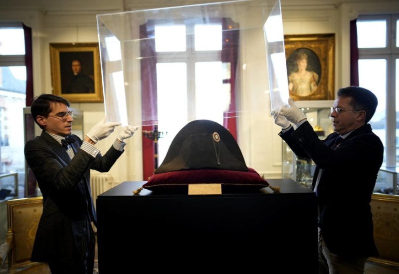 Raphael Pitchal, left, and Jean Christophe Chataignier of Osenat's auction house remove the protection of one of the signature broad, black hats that Napoléon wore when he ruled 19th century France and waged war in Europe at Osenat's auction house in Fontainebleau, south of Paris, Friday, Nov. 17, 2023