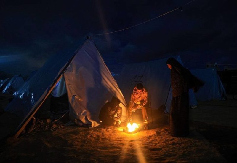 Displaced Palestinians gather next to tents sheltering people in Khan Yunis near the border fence between Israel and the southern Gaza Strip on November 27, 2023, amid a truce in battles between Israel and Hamas. (AFP)