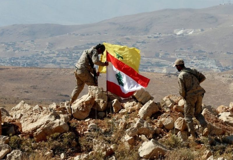 Hezbollah fighters fly movement's standard next to Lebanon's flag in Jouroud Arsal