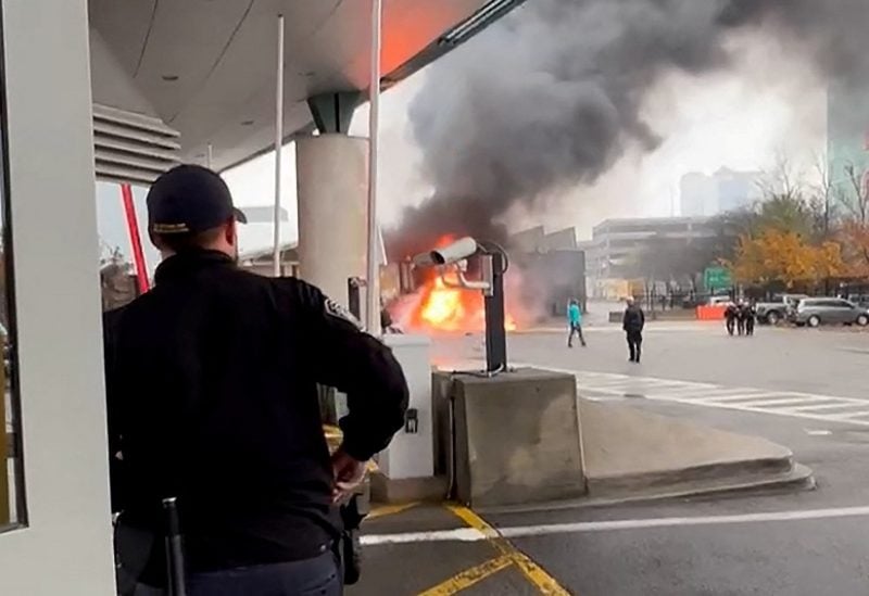 A Customs and Border Protection officer watches as a vehicle burns at the Rainbow Bridge U.S. border crossing with Canada, in Niagara Falls, New York, U.S. November 22, 2023 in a still image from video. Courtesy Saleman Alwishah via REUTERS THIS IMAGE HAS BEEN SUPPLIED BY A THIRD PARTY. MANDATORY CREDIT