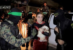 A dog is held by a hostage who was abducted by Hamas gunmen during the October 7 attack on Israel, while she and others are handed over by Hamas militants to members of the International Committee of the Red Cross, as part of a hostages-prisoners swap deal between Hamas and Israel amid a temporary truce, in an unknown location in the Gaza Strip, in this screengrab taken from video released November 28, 2023. Hamas Military Wing/Handout via REUTERS THIS IMAGE HAS BEEN SUPPLIED BY A THIRD PARTY. WATERMARK FROM SOURCE. TPX IMAGES OF THE DAY