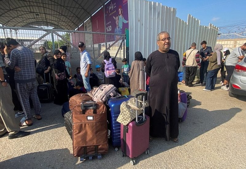 Palestinians with dual citizenship wait outside the Rafah border crossing with Egypt, in the hope of getting permission to leave Gaza, amid the ongoing conflict between Israel and Palestinian Islamist group Hamas, in Rafah in the southern Gaza Strip, November 1, 2023. REUTERS/Arafat Barbakh