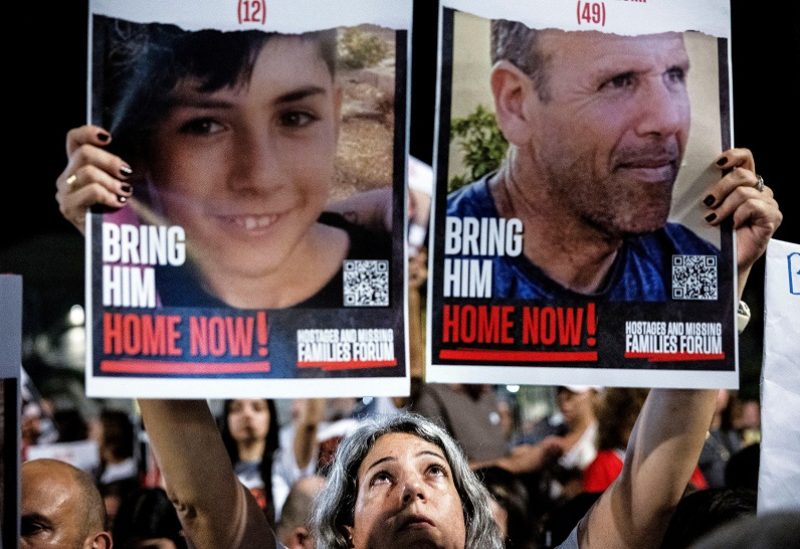 A person holds pictures during a protest to demand the immediate release of hostages held in Gaza who were seized in the October attack by Hamas gunmen, in Tel Aviv, Israel, November 4, 2023. REUTERS/Evelyn Hockstein TPX IMAGES OF THE DAY
