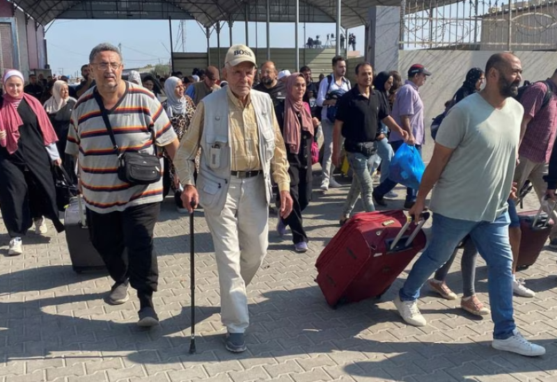 Palestinians with dual citizenship walk at the Rafah border crossing with Egypt, in the hope of getting permission to leave Gaza, amid the ongoing conflict between Israel and Palestinian Islamist group Hamas, in Rafah in the southern Gaza Strip, November 1, 2023