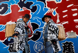 Keisuke Naka and Ikki Goto, members of Gomihiroi Samurai (trash-picking samurai) clad in denim yukata, poses for a photograph as they pick up trash on the street of Ikebukuro in the morning after Halloween in Tokyo, Japan November 1, 2023.