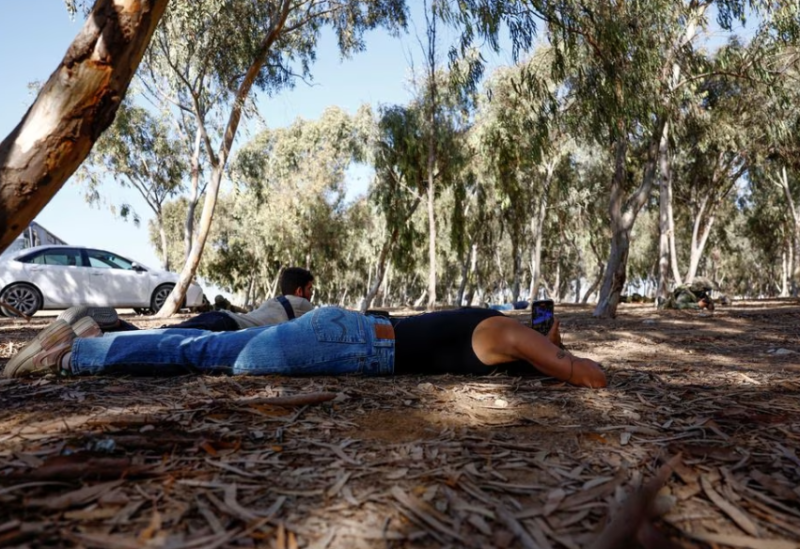 Bartender and survivor of the Nova Festival, May Hayat, takes cover as rocket sirens sound, during her first visit to the scene of the attack, on the one-month anniversary of the attack by the Palestinian Islamist group Hamas on October 7th, near Re'im, Israel November 6, 2023