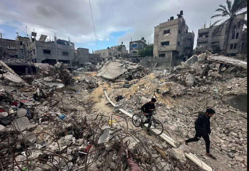 Palestinians walk among the rubble, as they inspect houses destroyed in Israeli strikes during the conflict, amid the temporary truce between Hamas and Israel, at Khan Younis refugee camp in the southern Gaza Strip November 27, 2023.