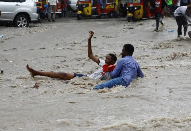 A man attempts to rescue a boy from raging flood waters following heavy rains in Mogadishu, Somalia November 9, 2023