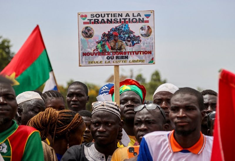 FILE PHOTO: A person holds a sign with a picture of Captain Ibrahim Traore while attending a rally by supporters of Burkina Faso's junta to mark the one-year anniversary of the coup that brought Traore to power in Ouagadougou, Burkina Faso September 29, 2023.REUTERS/ Yempabou Ouoba/File Photo