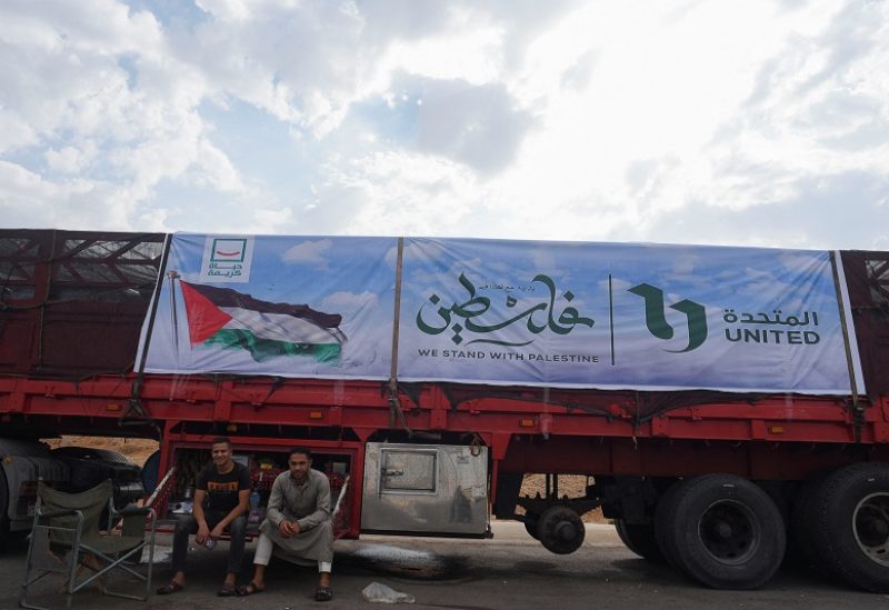 People rest near a truck carrying humanitarian aid to Palestinians, on a desert road (Cairo - Ismailia) on the way to the Rafah border crossing to enter Gaza, amid the ongoing conflict between Israel and the Palestinian Islamist group Hamas, in Cairo, Egypt, November 12, 2023. REUTERS/Hadeer Mahmoud