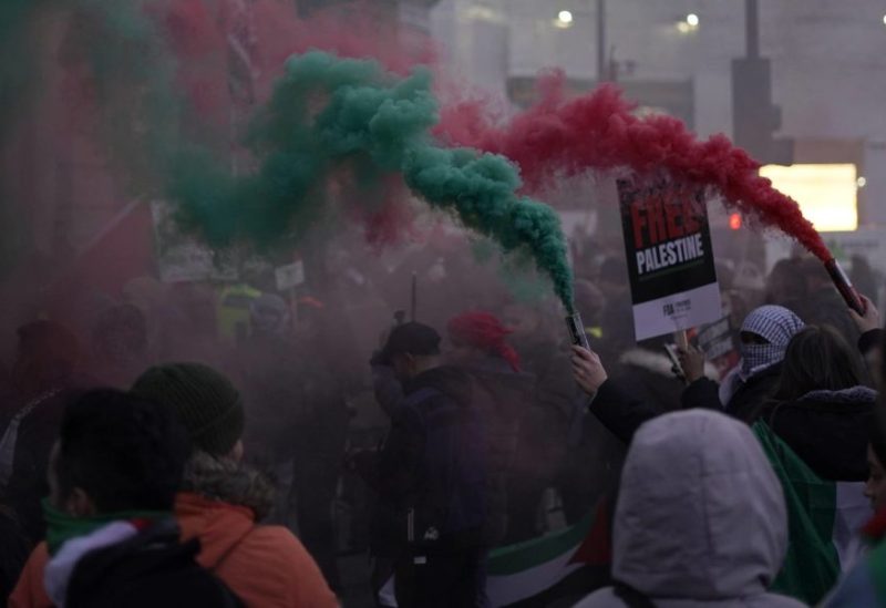 Flares are let off by protesters as others hold flags and placards during a pro-Palestinian demonstration in Trafalgar Square in London, Saturday, Nov. 25, 2023