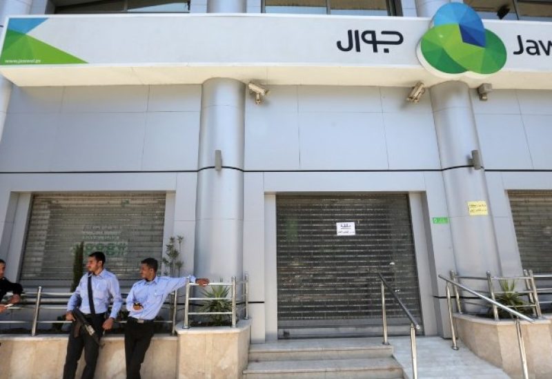 Palestinian policemen loyal to Hamas stand guard outside the closed Jawwal company headquarters in Gaza City June 30, 2015. (Reuters)