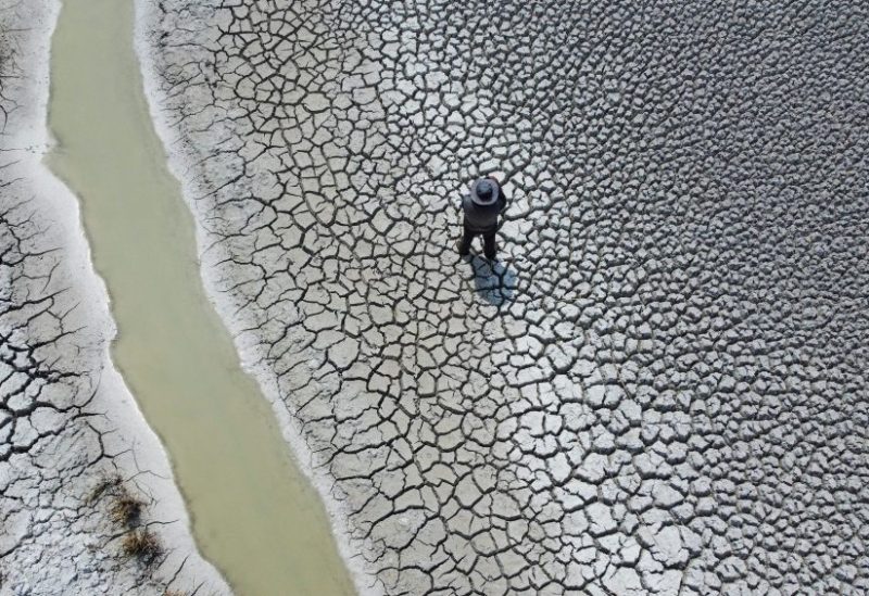 Manuel Flores walks on a dry area that shows the drop in the level of Lake Titicaca, Latin America's largest freshwater basin, as it is edging towards record low levels, on Cojata Island, Bolivia October 26, 2023. REUTERS/Claudia Morales/File Photo