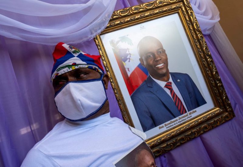 A man stands next to a portrait of slain Haitian President Jovenel Moise placed on a memorial at the city hall in Cap-Haitien, Haiti July 22, 2021. REUTERS/Ricardo Arduengo/File Photo