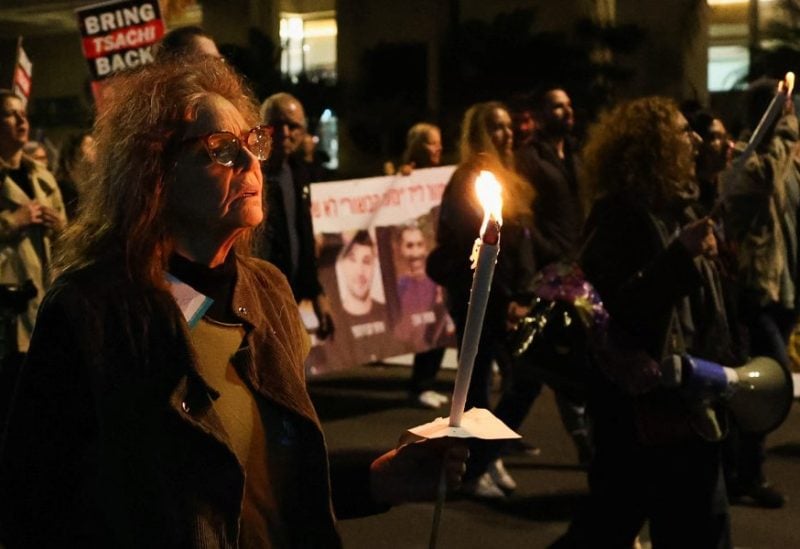 A woman holds a candle as people protest following an announcement by Israel's military that they had mistakenly killed three Israeli hostages being held in Gaza by Palestinian Islamist group Hamas, at a demonstration in Tel Aviv, Israel, December 15, 2023. REUTERS/Violeta Santos Moura