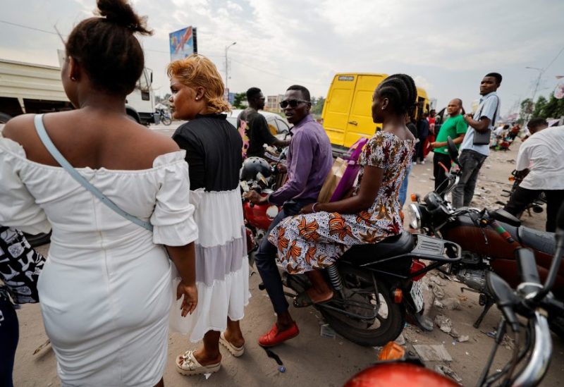 A motorcycle taxi rider reacts as he transports a customer in Kinshasa, the Democratic Republic of Congo December 16, 2023. REUTERS/Zohra Bensemra