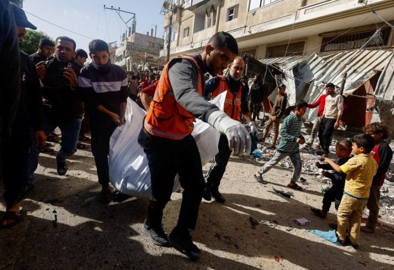 Palestinians carry a casualty near the site of an Israeli strike on a car, amid the ongoing conflict between Israel and the Palestinian Islamist group Hamas, in Rafah, southern Gaza Strip December 22, 2023. REUTERS/Mohammed Salem