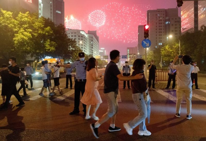 People watch a rehearsal of a fireworks display near the National Stadium ahead of the 100th founding anniversary of the Communist Party of China in Beijing, China June 25, 2021. REUTERS/Thomas Peter/File Photo