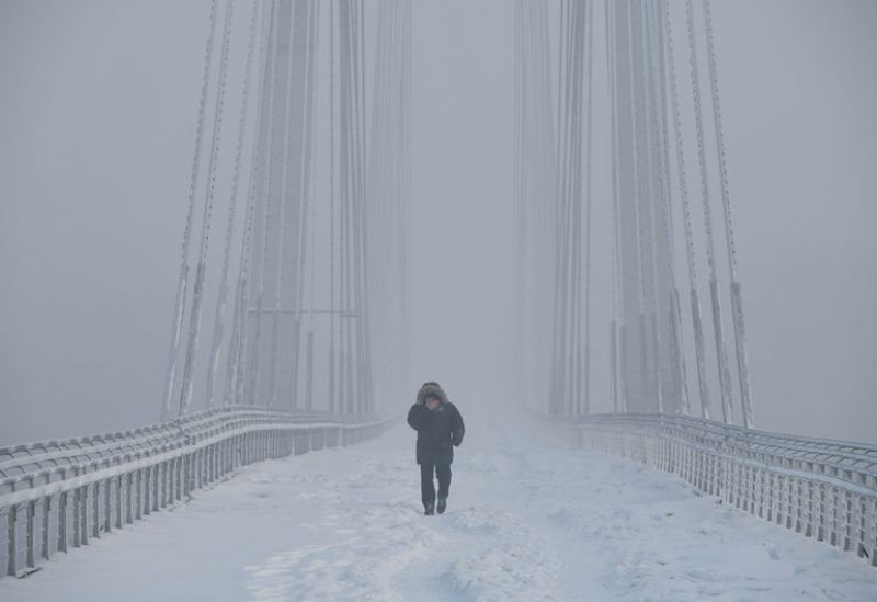A man walks on the Vinogradovsky Bridge across the Yenisei River, as the air temperature plunges as low as minus 35 degrees Celsius (minus 31 degrees Fahrenheit), in the Siberian city of Krasnoyarsk, Russia, December 12, 2023. REUTERS/Alexander Manzyuk/ File photo