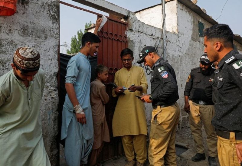Police officers, along with workers from the National Database and Registration Authority (NADRA), check the identity cards of Afghan citizens during a door-to-door search and verification drive for undocumented Afghan nationals, in an Afghan Camp on the outskirts of Karachi, Pakistan, November 21, 2023. REUTERS/Akhtar Soomro/ FILE PHOTO