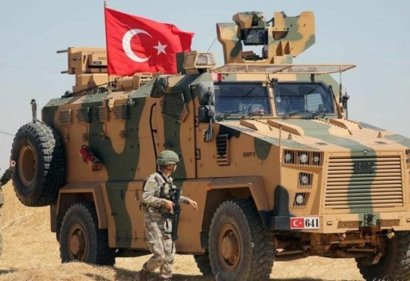 Turkish soldiers walk near their vehicle. Reuters