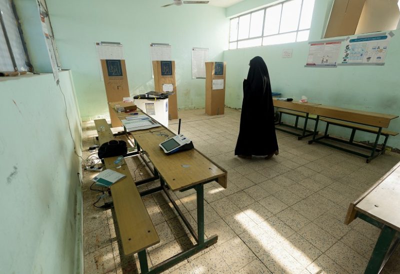 A woman walks in the election hall during Iraq's provincial council elections, at a polling station in Najaf, Iraq, December 18, 2023. REUTERS/Alaa al-Marjani