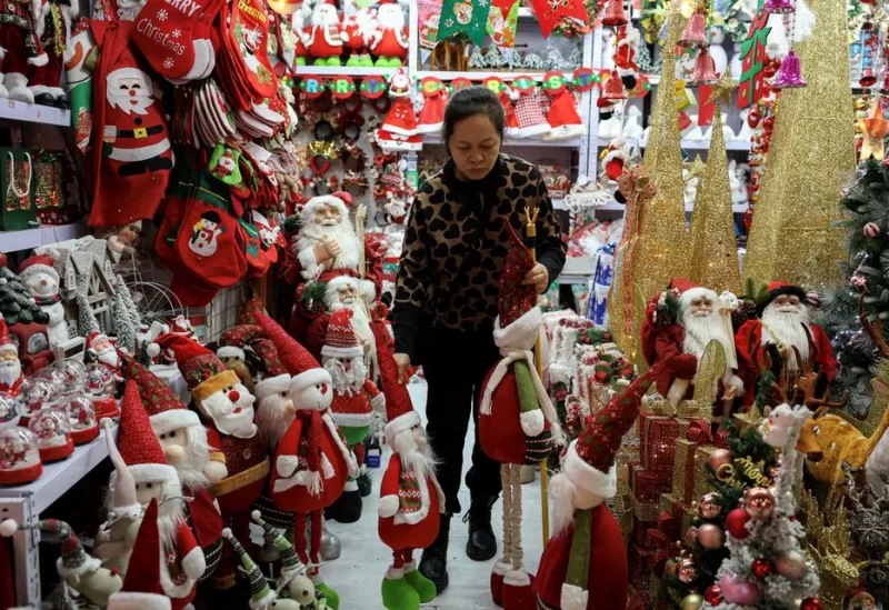 A vendor sorts products at a booth selling Christmas decorations at a mall in Beijing, China December 14, 2023. REUTERS